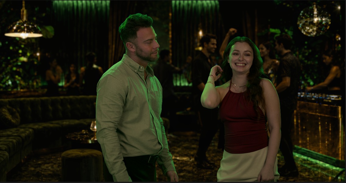 In-game scene: the protagonist and Bella in a green-lit lounge